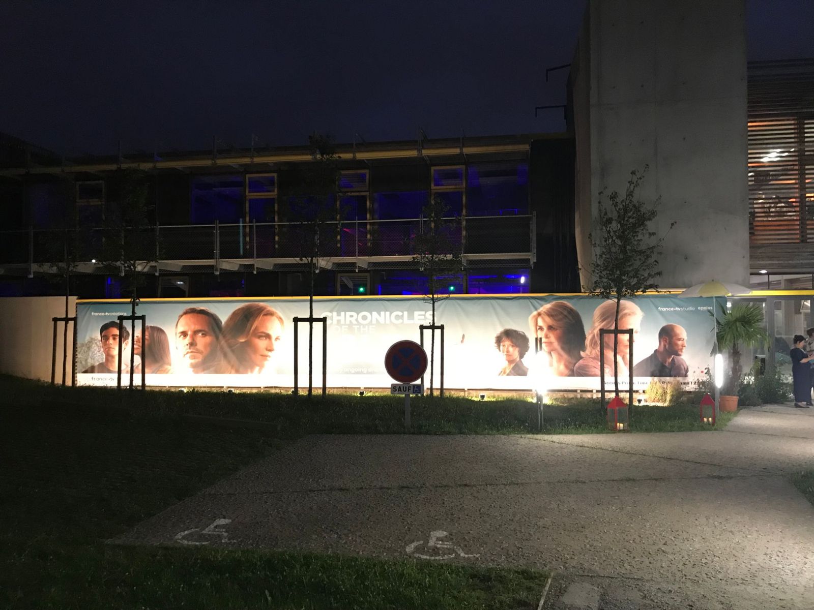 Banderole de 35 mètres aux visuels de la série « Chronicles of the Sun », éclairée de nuit le long du bâtiment.